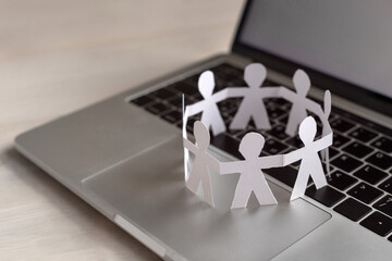 online community concept, virtual group of people, paper humans stand together in circle on computer keyboard - obrazy, fototapety, plakaty