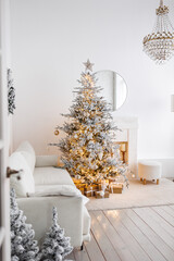 Snow-white Christmas tree, luxury, decorated with a golden garland, with gifts for the day in a...