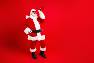 Full size photo of funky grandfather wear stylish santa costume hold megaphone screaming in empty space isolated on red color background - obrazy, fototapety, plakaty