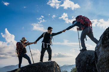 group of mountaineers give helping hands during hiking on top of mountains