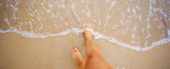 A beautiful girl in a bikini on a wild beach, bathing in the clear waves of the warm sea. a...