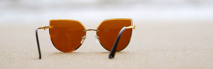 Sunglasses in the waves of the warm sea on vacation, a paradise beach and beautiful sunglasses in...