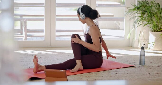 Woman, yoga and pilates in online class, fitness or zen workout on mat with headphones in living room at home. Calm female person or yogi in body warm up, stretching or tablet for tutorial or lesson