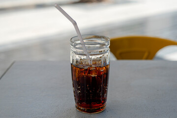 A glass of soda on a table with ice