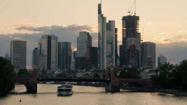 Wide Clip Of Alte Bride Frankfurt As Tour Boat Passes Under. Frankfurt Skyline Is Behind. Shot On Summer Evening