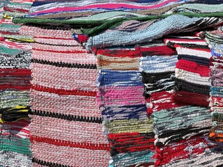 Pile of colorful fabrics rugs for sale in the market.