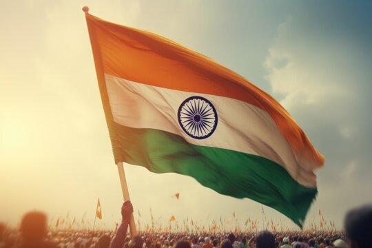 A person proudly holds an Indian flag in front of a lively crowd. This image can be used to depict patriotism, national celebrations, cultural events, or demonstrations.