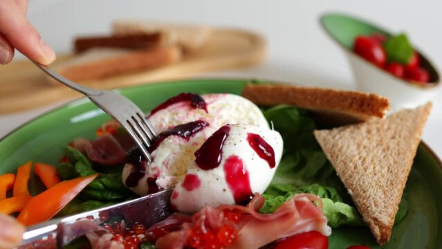 Delicious burrata cheese served with vegetables, berry jam and seafood. Italian appetizer. The concept of a vegetarian lifestyle and healthy eating.