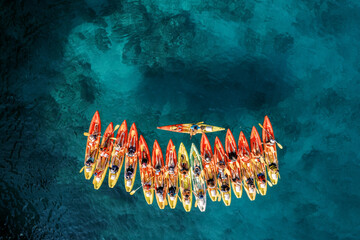 Row of red and yellow kayaks on the turquoise sea. Top view