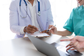 Doctor discussing diagnosis during the meeting. Group of doctor discussing work matter in the office at work. The medical team discusses treatment options with the patient.