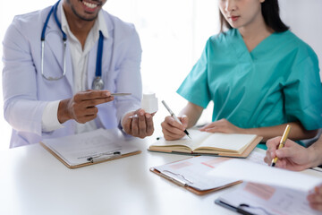 Doctor discussing diagnosis during the meeting. Group of doctor discussing work matter in the office at work. The medical team discusses treatment options with the patient.