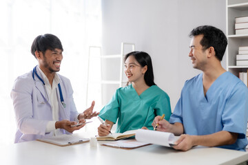 Fototapeta premium Doctor discussing diagnosis during the meeting. Group of doctor discussing work matter in the office at work. The medical team discusses treatment options with the patient.
