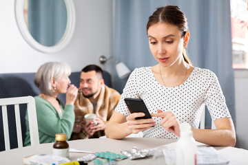 Obraz premium Young wife carefully reads the annotation for medicines and checks the information on the Internet