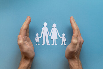 Fototapeta na wymiar family insurance concept, family law, paper family with two children on blue background