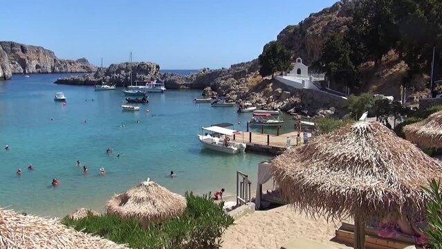 People enjoying the picturesque bay of St Paul&rsquo;s Bay in Rhodes Island, Greece.