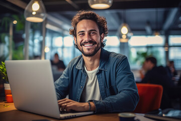 Portrait of attractive smiling man sitting in office and looking at camera..