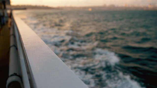 Top view of deck and side of wooden boat sailing on sea. Ship cuts through foamy white waves of deep blue sea. White Bubble Ejected By Moving Propeller Outboard Motor With White Foam