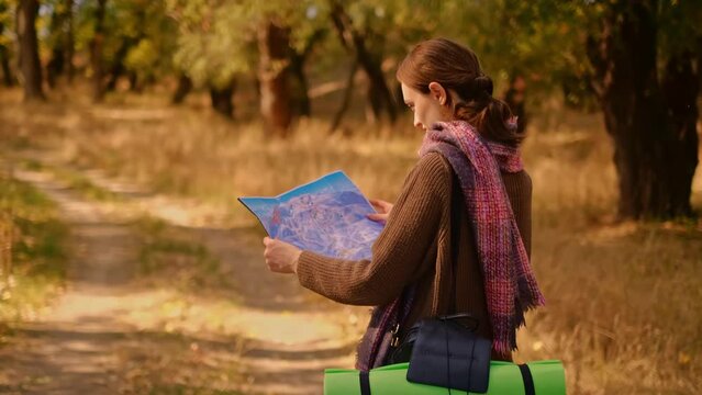 a woman in the forest with a map, a girl drinking tea in the forest, a topographic map in her hands, a girl with a backpack in the forest, travel adventure, orienteering in the forest, MyRealHoliday