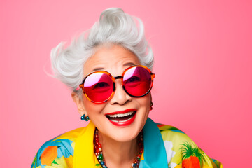 Funny stylish elderly asian grandmother in glasses poses at studio. Senior old woman looking at camera over bright background  - obrazy, fototapety, plakaty