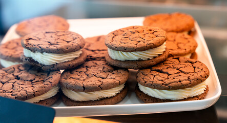 Fresh chocolate cookies in a glass showcase in a cafe or shop. Close-up. Selective focus.