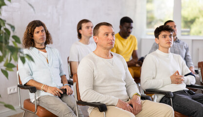 Fototapeta premium Group of men in the audience attentively listens to a lecture on same-sex relationships