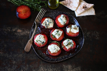 Baked plums with dor blue cheese on a plate.