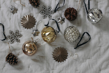 Stylish old Christmas ornaments. Vintage glass baubles, balls. Pine cones on grey muslin blanket, throw. Decorative winter composition on table. Merry Christmas decor. Moody festive holidays banner.