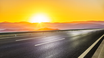 Asphalt highway and mountain natural landscape at sunrise