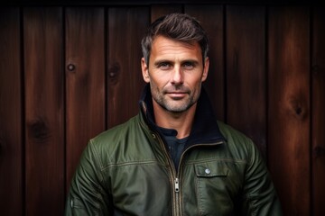Portrait of a tender man in his 40s sporting a stylish varsity jacket against a rustic wooden wall. AI Generation