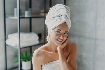 A serene woman in a spa with a towel on her head, exuding tranquility and wellness