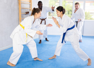 Two female athletes playing Judo in sport hall
