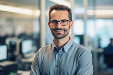 Obraz premium Portrait of successful mature boss, senior businessman in glasses and business suit looking at camera and smiling, man with crossed arms working inside modern office building.