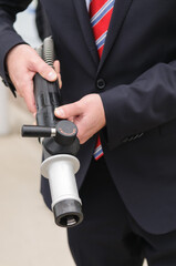 A man holds the high pressure (350 bar) nozzel at a hydrogen fuel filling pump station. - obrazy, fototapety, plakaty