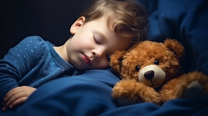 A sleeping child hugging a teddy bear in navy blue couch