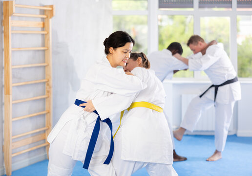 Cosmopolite sportsmen during classes, training improve and practice wrestling with opponent in technique of martial arts. Work on yourself, increase endurance, determination, courage