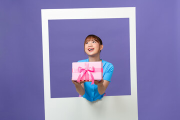Photo of charming excited lady hold present box looking inside photo frame empty space on color...