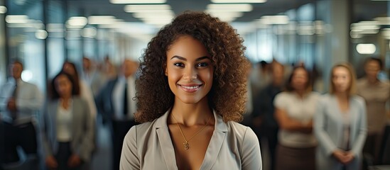 In the background of a bustling office a young and beautiful black woman exudes confidence and happiness as she leads her team with the grace of a true corporate leader all while the camera 