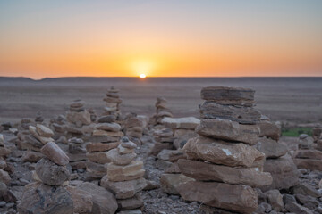 Stack of stone piled up on a hill in the Sahara Desert next to Ait Benhaddou during sunset