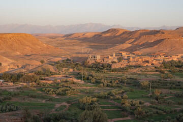 Village in the green fertile riverbed of the Draa river in the Sahara Desert with typical...