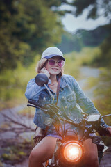 pretty woman riding sport enduro motorcycle on dirt field