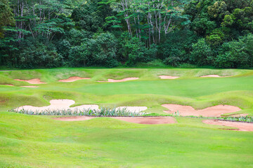 Bunkers around golf green at base of Koolau Mountains, Oahu Hawaii.