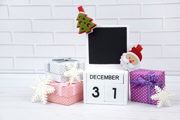 Wooden calendar with the date December 31st with holiday decorations.