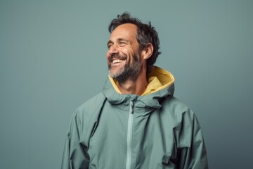 Portrait of a jovial man in his 40s wearing a functional windbreaker against a pastel gray background. AI Generation