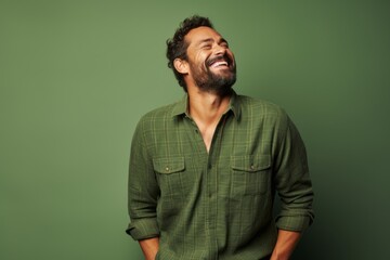 Portrait of a joyful man in his 30s wearing a comfy flannel shirt against a soft green background. AI Generation