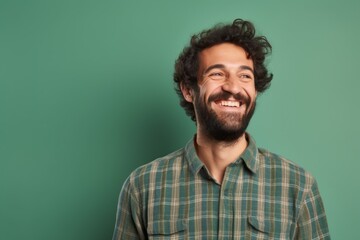 Portrait of a joyful man in his 30s wearing a comfy flannel shirt against a soft green background. AI Generation