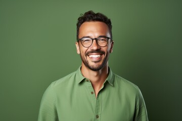 Fototapeta premium Portrait of a smiling man in his 30s wearing a simple cotton shirt against a soft green background. AI Generation
