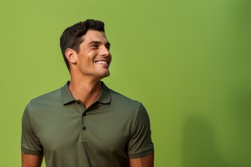 Fototapeta premium Portrait of a blissful man in his 20s wearing a breathable golf polo against a soft green background. AI Generation