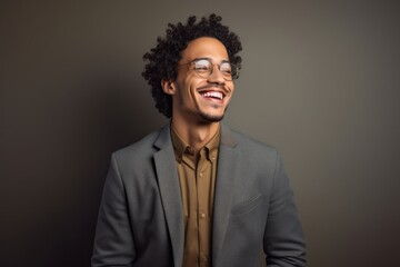 Obraz premium Portrait of a happy man in his 20s dressed in a stylish blazer against a soft gray background. AI Generation