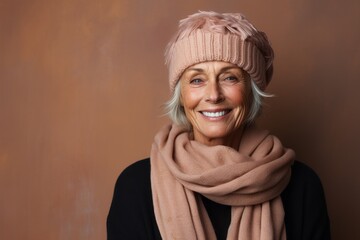 Portrait of a joyful woman in her 60s donning a warm wool beanie against a soft brown background. AI Generation - Powered by Adobe