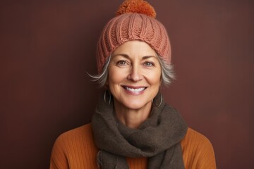 Portrait of a joyful woman in her 60s donning a warm wool beanie against a soft brown background. AI Generation